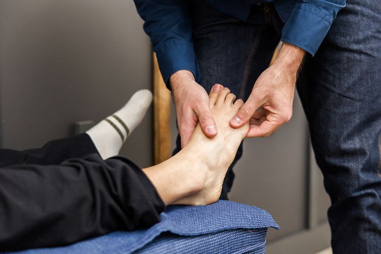 Close-up of hands-on care to the small bones of the forefoot
